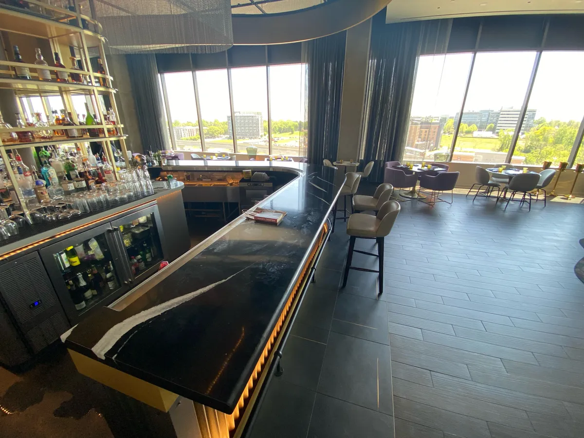 Stone bar counter with seating and floor-to-ceiling windows